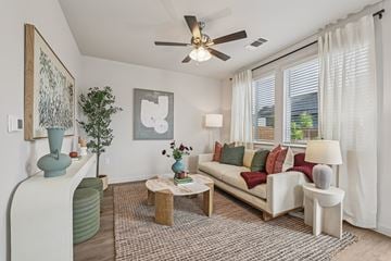 Pflugerville apartment for rent - A living room with a white couch and a ceiling fan.
