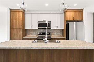 Dieppe apartment for rent - A modern kitchen with wooden cabinets and a central island.