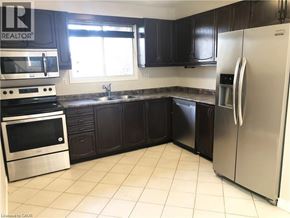 Hamilton apartment for rent - A kitchen with a refrigerator, oven, and sink.