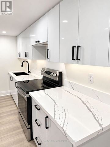 Vaughan (Kleinburg) apartment for rent - A modern kitchen with white cabinets and marble countertops.