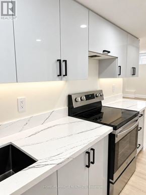 Vaughan (Kleinburg) apartment for rent - A kitchen with white cabinets and black appliances.