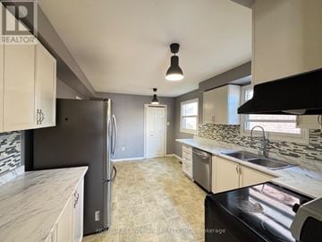 Barrie (Northwest) apartment for rent - A kitchen with a black fridge and a black stove top oven.