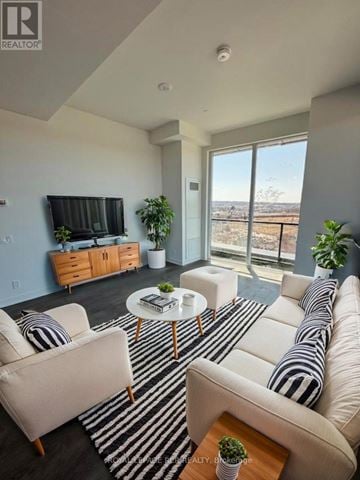 Barrie (City Centre) condo for rent - A living room with a striped rug and a white couch.