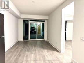 Mississauga (City Centre) condo for rent - A room with a sliding glass door and wooden flooring.