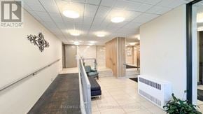 St. Catharines (Glendale/Glenridge) condo for rent - A hallway with a bench and a wall with a sign that says REALTOR.