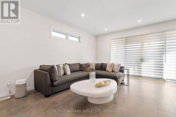 Thorold (Confederation Heights) townhouse for rent - A living room with a grey couch and a white coffee table.
