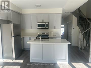 Kawartha Lakes (Lindsay) townhouse for rent - A kitchen with white cabinets and appliances is shown.