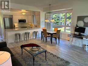 Collingwood townhouse for rent - A modern kitchen with a breakfast bar and a dining table with chairs.