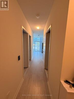 Toronto (Mimico) condo for rent - A long hallway with doors on both sides and a light on the ceiling.