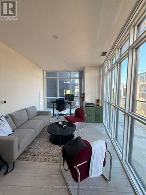 Toronto (Mimico) condo for rent - A living room with a grey couch, a black coffee table, and a red chair.