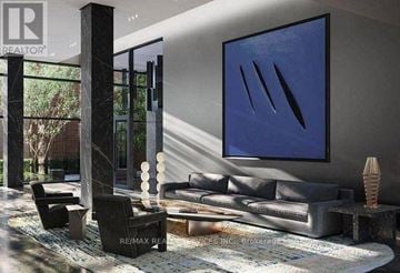 Hamilton (Beasley) condo for rent - A modern living room with a grey sofa and a large blue painting on the wall.