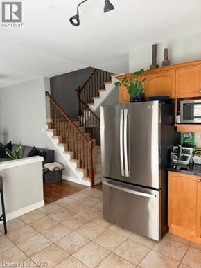 Burlington apartment for rent - A stainless steel refrigerator in a kitchen with wooden cabinets.