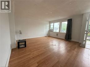 Kitchener apartment for rent - A room with wooden flooring and a window with curtains.
