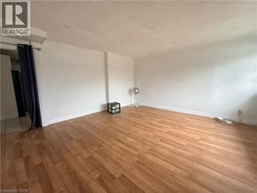 Kitchener apartment for rent - A room with wooden flooring and a white wall.