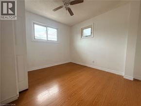 Kitchener apartment for rent - A room with wooden flooring and two windows.