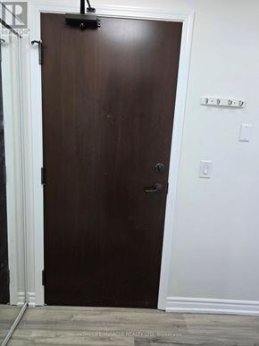 Mississauga (City Centre) condo for rent - A brown door with a black handle and a black latch on the side.