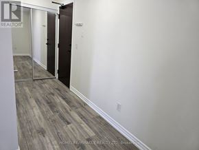Mississauga (City Centre) condo for rent - A room with a wooden floor and white walls.