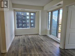 Mississauga (City Centre) condo for rent - A room with wooden floors and a large window overlooking a cityscape.