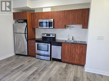 Mississauga (City Centre) condo for rent - A kitchen with wooden cabinets and a refrigerator.