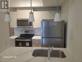 Toronto (Glenfield-Jane Heights) condo for rent - A kitchen with a stainless steel refrigerator, microwave, and oven.