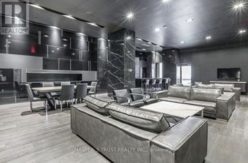 Toronto (Waterfront Communities) condo for rent - A modern living room with a large sectional sofa and a dining table.