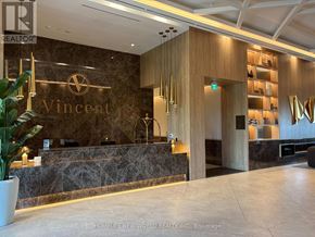 Vaughan (Vaughan Corporate Centre) condo for rent - The lobby of a building with a reception desk and a plant.