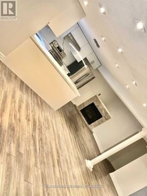 Richmond Hill (Devonsleigh) apartment for rent - A modern kitchen with a wood grain wall and a stove top oven.