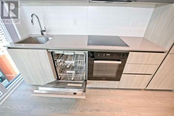 Toronto (Waterfront Communities) condo for rent - A modern kitchen with a stainless steel dishwasher and oven.