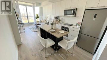 Toronto (Henry Farm) condo for rent - A kitchen with a table and chairs in front of a refrigerator.