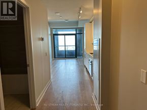 Vaughan (Concord) condo for rent - A hallway with a door on the left and a kitchen area on the right.