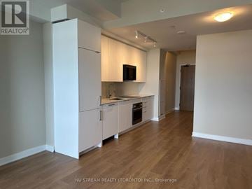Vaughan (Concord) condo for rent - A kitchen with white cabinets and a wooden floor.