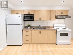 Markham (Raymerville) apartment for rent - A kitchen with wooden cabinets and white appliances.