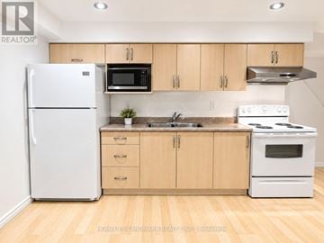 Markham (Raymerville) apartment for rent - A kitchen with wooden cabinets and white appliances.