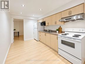 Markham (Raymerville) apartment for rent - A white stove is in a kitchen with wooden floors and white walls.