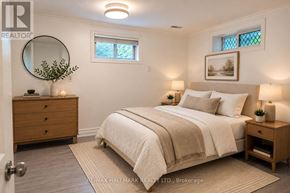 Aurora (Aurora Highlands) apartment for rent - A bedroom with a bed, nightstand, and a round mirror on the wall.