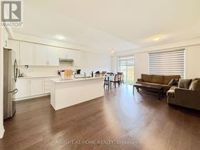 Barrie apartment for rent - A well-lit kitchen and living room with wooden floors and white cabinetry.