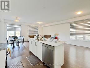 Barrie apartment for rent - A kitchen with white cabinets and a dining table with chairs.