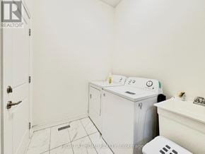 Barrie apartment for rent - A white bathroom with a washing machine and dryer in it.