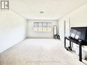 Barrie apartment for rent - A living room with a television and a window with blinds.