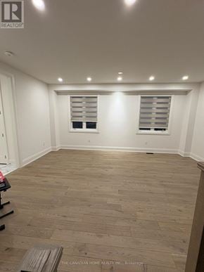 Brampton (Northwest Brampton) apartment for rent - A room with wooden flooring and two windows with blinds.