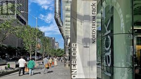 Toronto (Church-Yonge Corridor) condo for rent - A group of people walking down a sidewalk past a building with a large sculpture of a man's face.