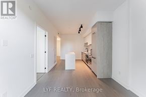 Toronto (Forest Hill South) condo for rent - A spacious, empty room with a kitchen area visible in the background.
