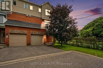 Ottawa townhouse for rent - A house with a garage and a tree in front of it.