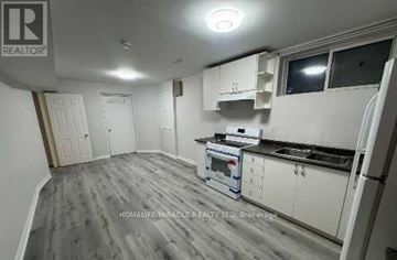 Brampton (Snelgrove) apartment for rent - A kitchen with white cabinets and a grey floor.