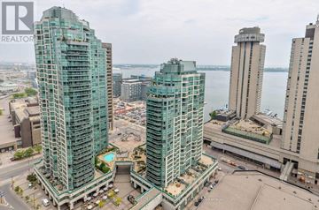 Toronto (Waterfront Communities) condo for rent - Two tall buildings with a pool in the middle.