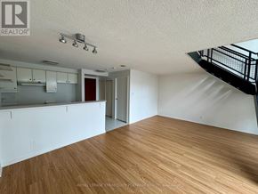 Toronto (Waterfront Communities) condo for rent - A room with wooden floors and a staircase on the right side.