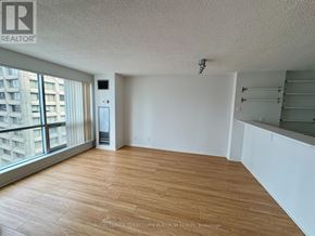 Toronto (Waterfront Communities) condo for rent - A room with wooden flooring and a large window overlooking a building.
