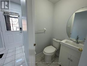 Mississauga (Lisgar) townhouse for rent - A white bathroom with a toilet, sink and mirror.