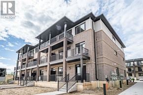 Guelph (Kortright East) townhouse for rent - A modern apartment building with balconies and a clear sky in the background.