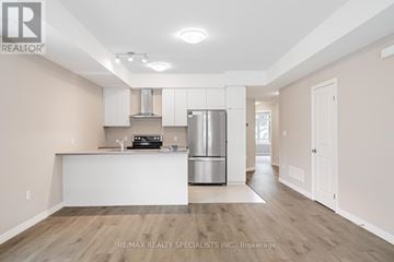 Guelph (Kortright East) townhouse for rent - A kitchen with white cabinets and a stainless steel refrigerator.